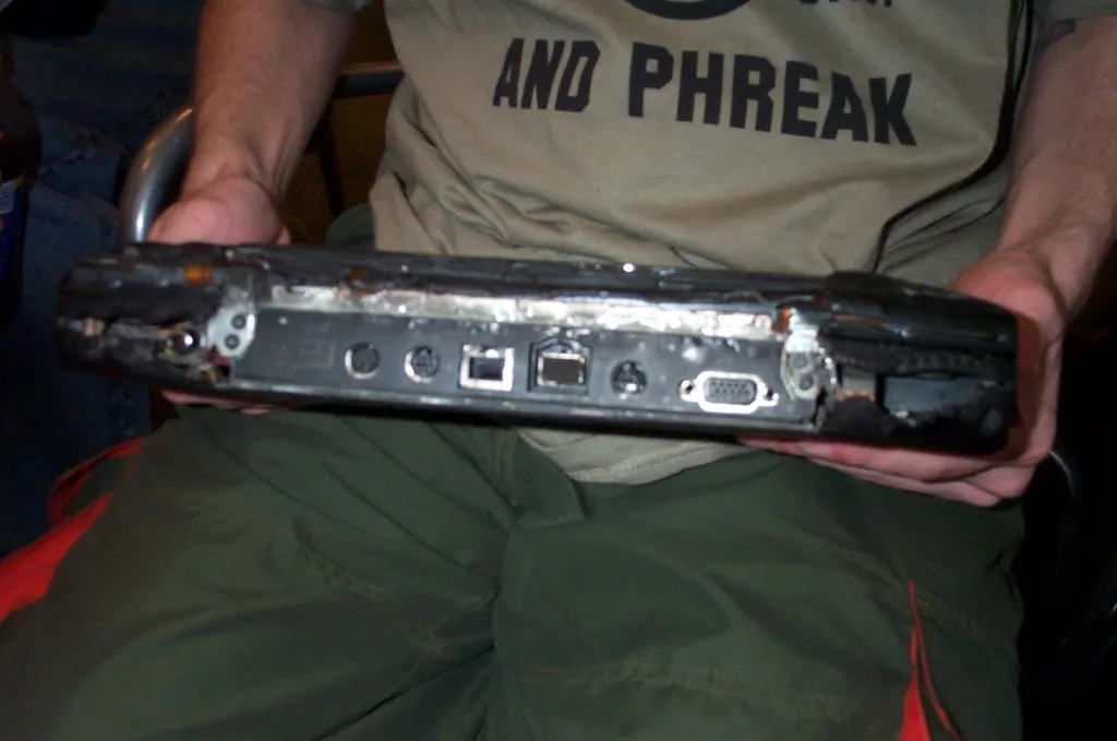 Back of the burned laptop held by phiz.