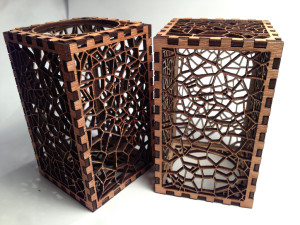 Laser-cut wooden boxes, with random organic-looking cutouts.